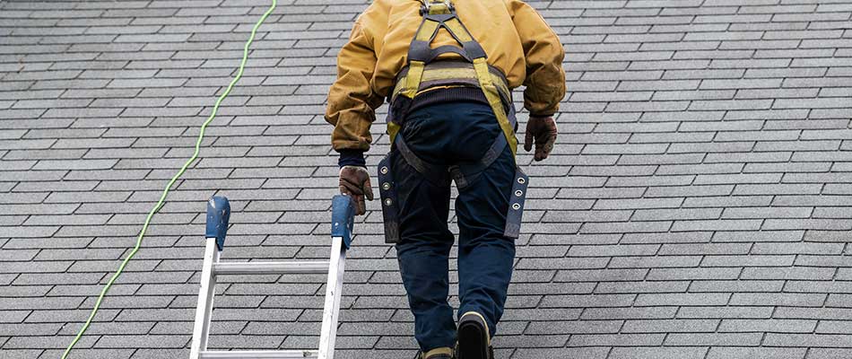 Roofing worker inspecting a home roof in Winter Haven, FL.