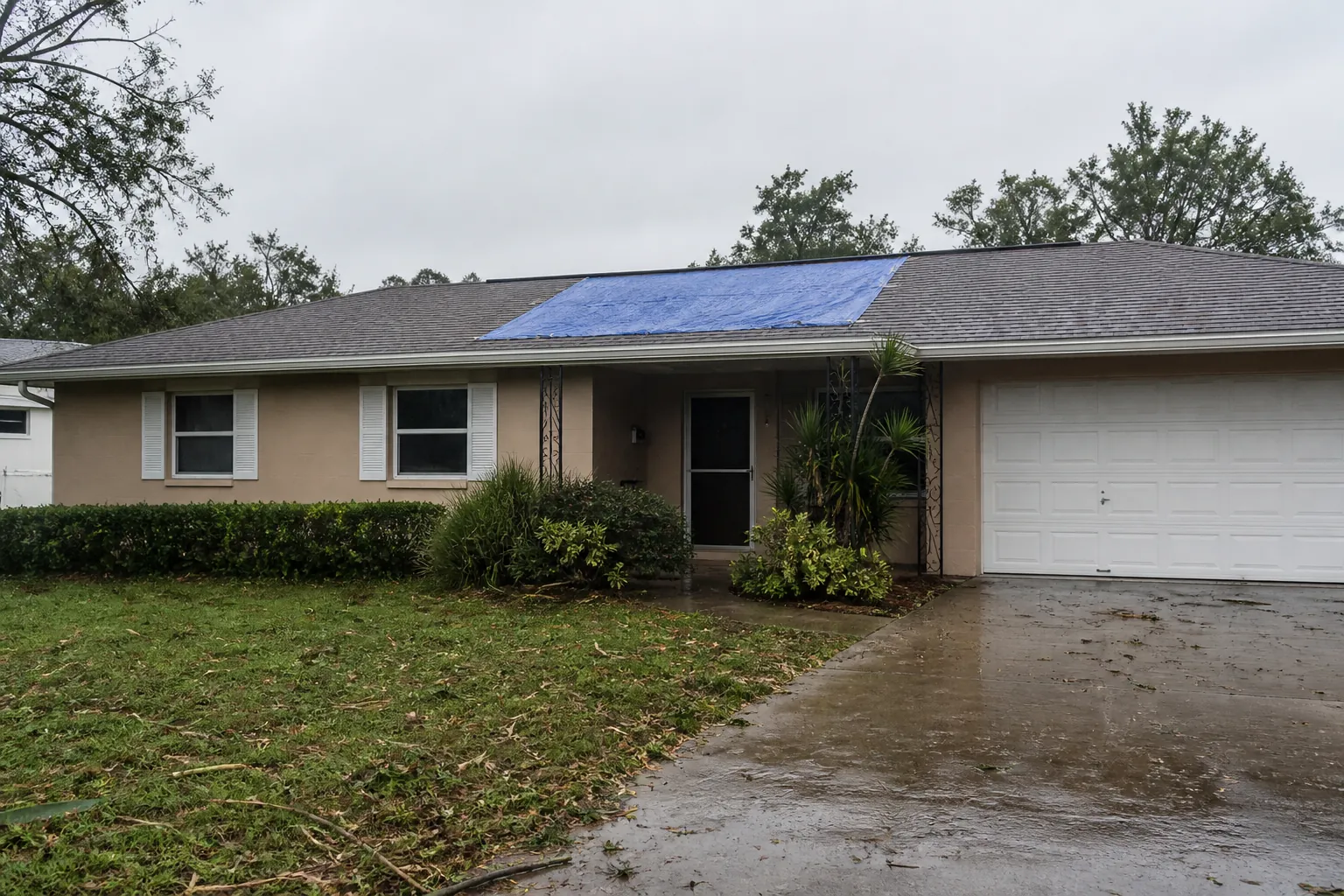 Emergency tarp on a Lakeland shingle roof after a storm, waiting for permanent repair