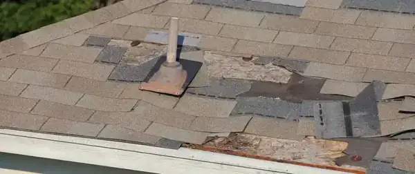 Storm-damaged asphalt shingles on a Central Florida roof, the kind of section damage that can trip Florida's 25% roofing rule