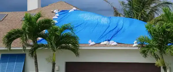 Emergency roof tarp anchored over storm-damaged shingles on a Central Florida home